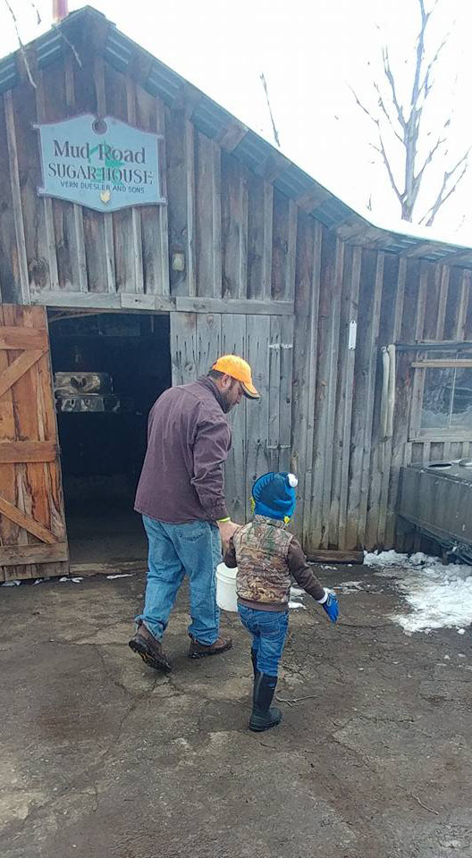 carrying bucket of sap to tank